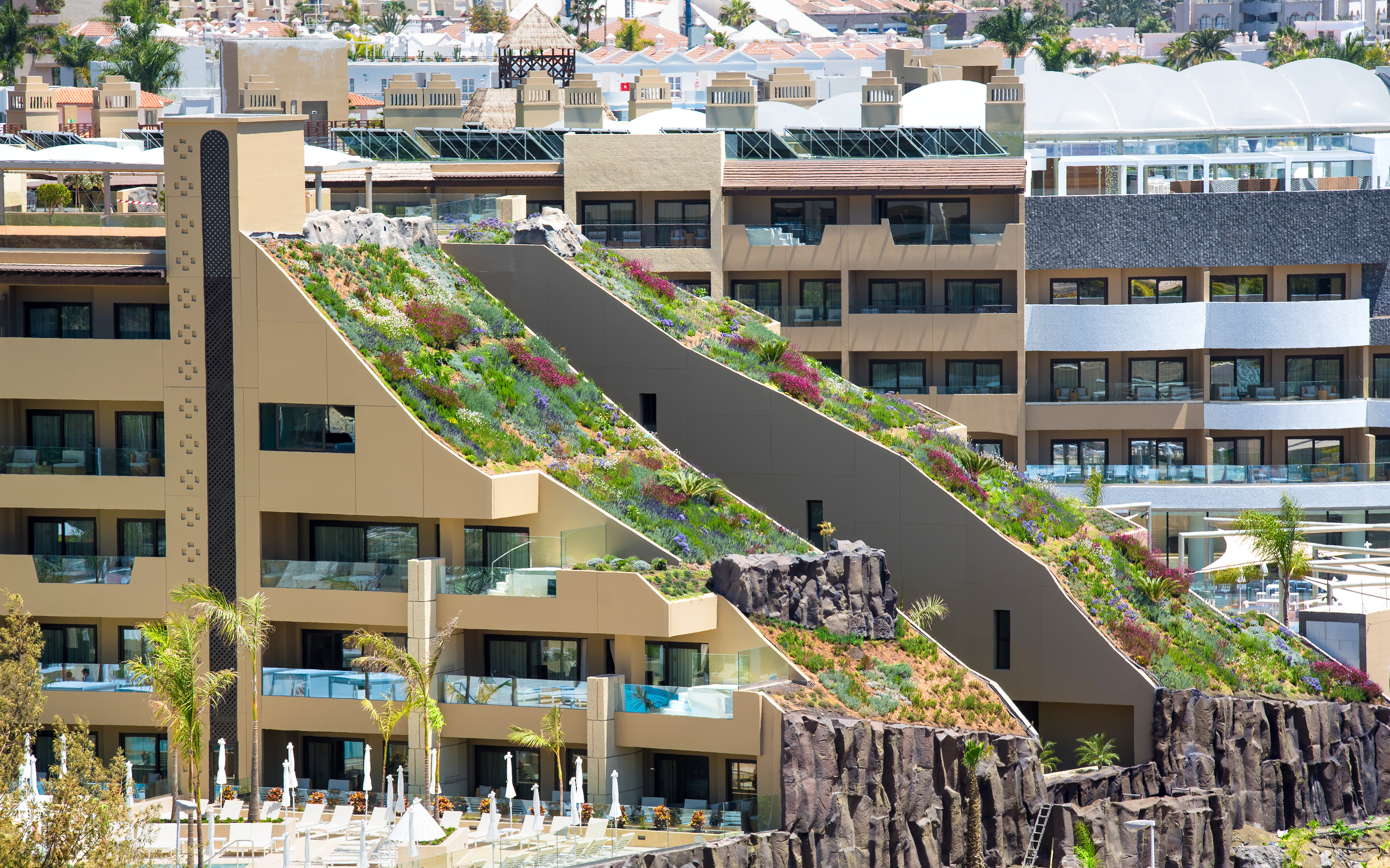 Thanks to its three steep pitched green roofs the GF Victoria luxury hotel has become a visual attraction. Hotel building with two steep pitched green roofs
